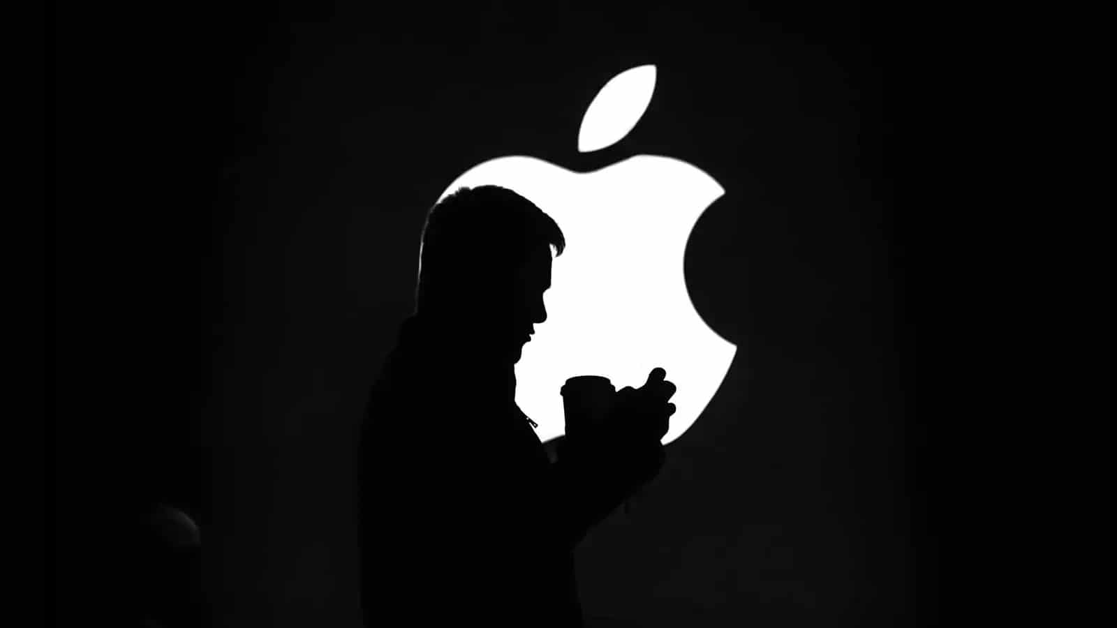 silhouette of a man with an Apple logo in the background