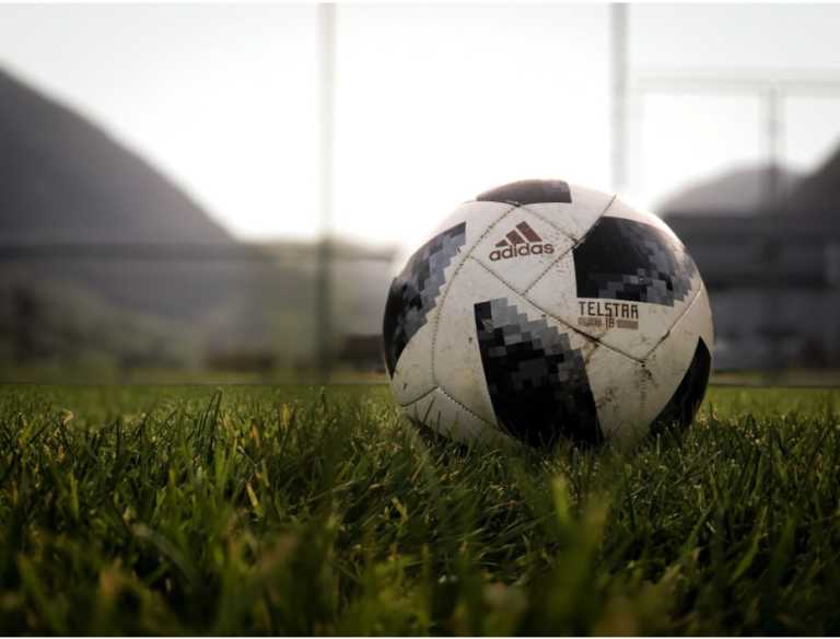 adidas football ball in the middle of the field